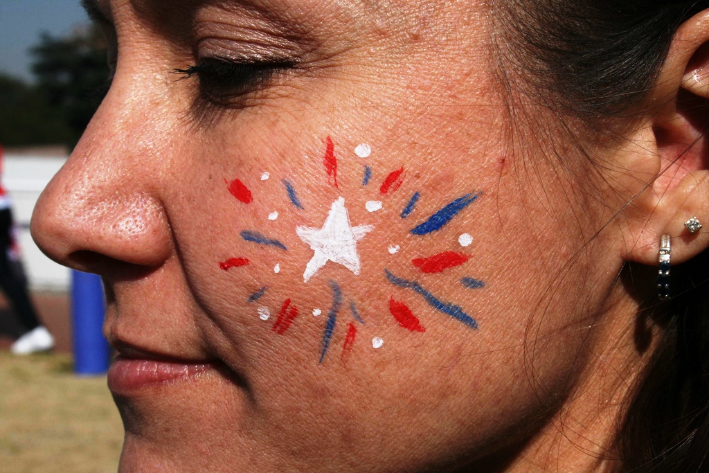 A fan with her face painted in her team's colours
