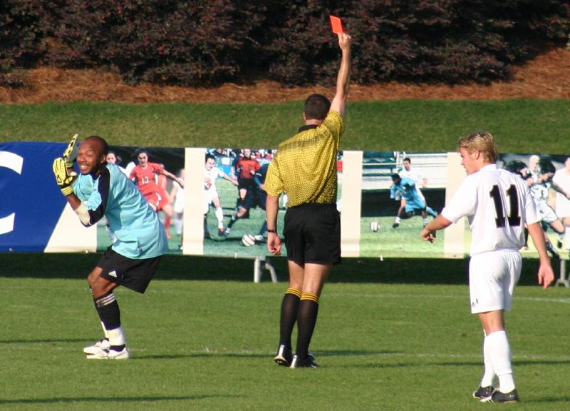 A referee shows a red card during a match